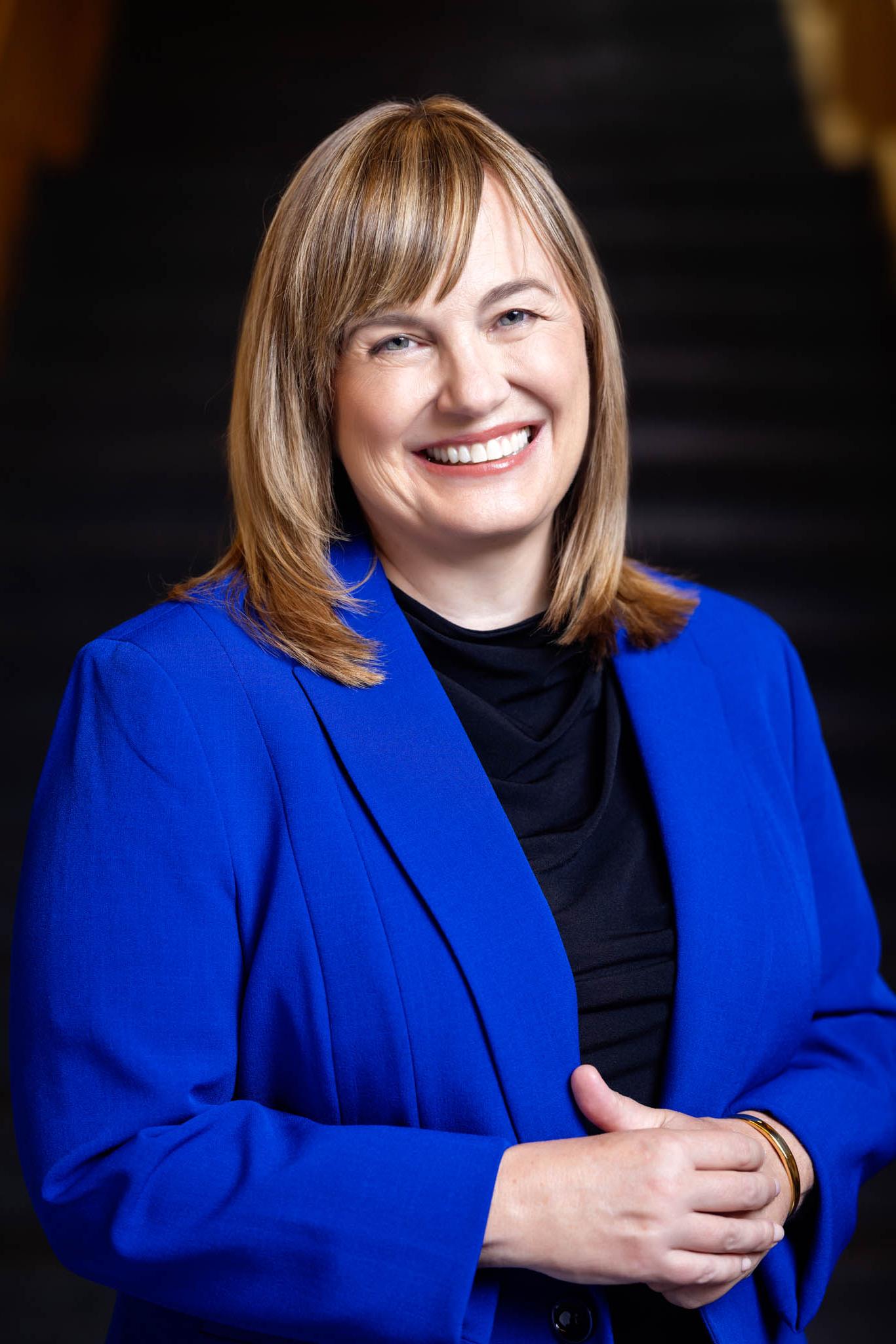 Laura Rosenbury wearing a bright blue blazer, smiling